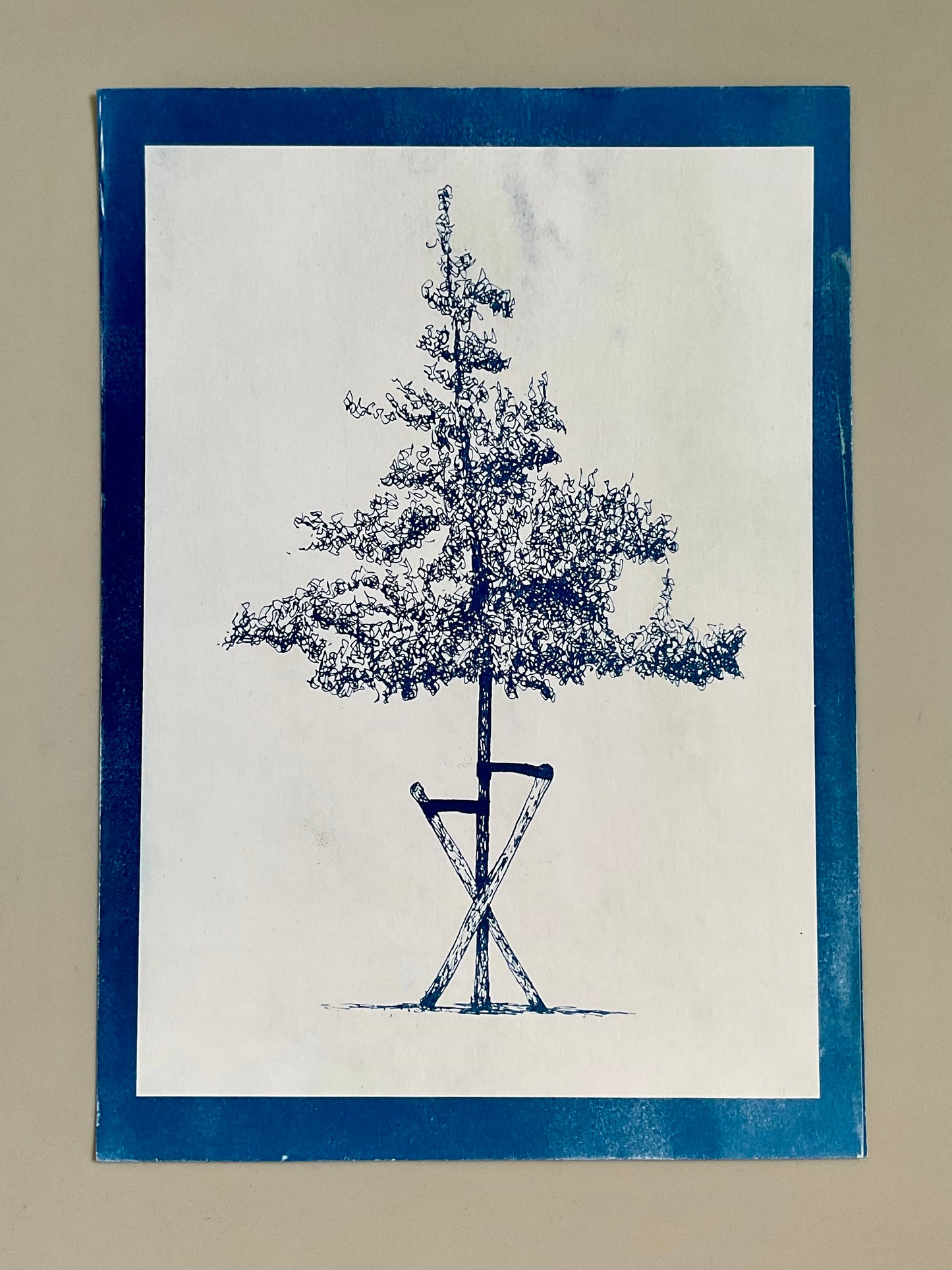 Cyanotype print of a slender tree supported by wooden stakes, printed in rich indigo tones on A4 paper.