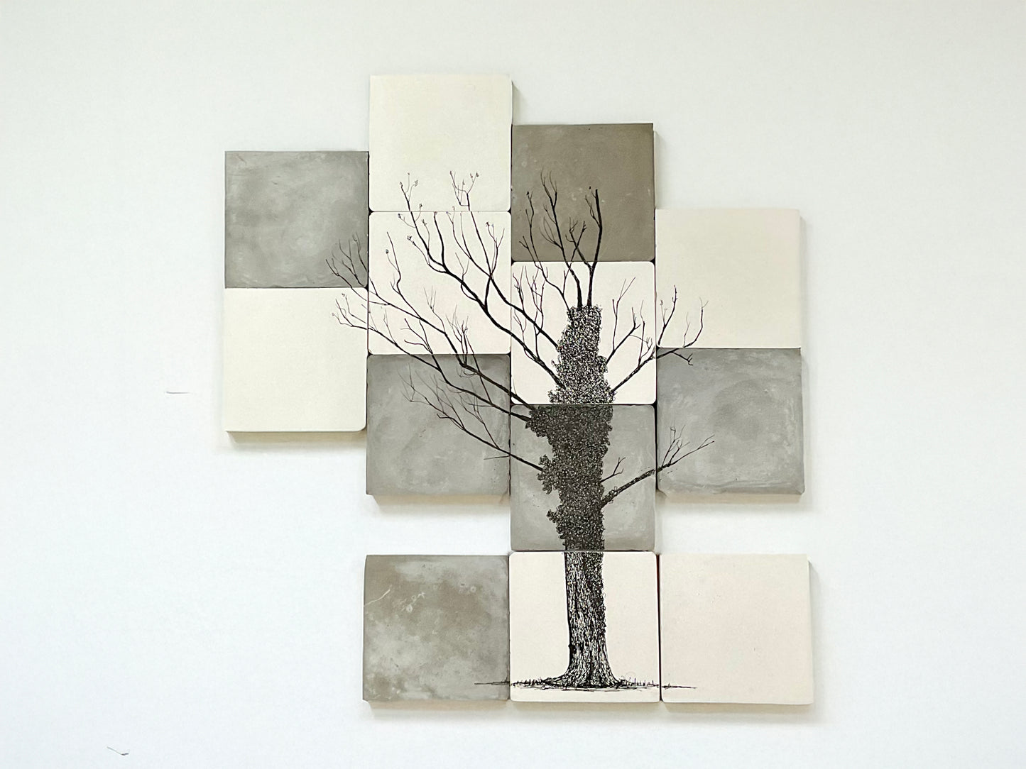 Ink drawing of an ivy-covered oak tree illustrated across twelve hand-cast cement tiles in tones of grey and white.