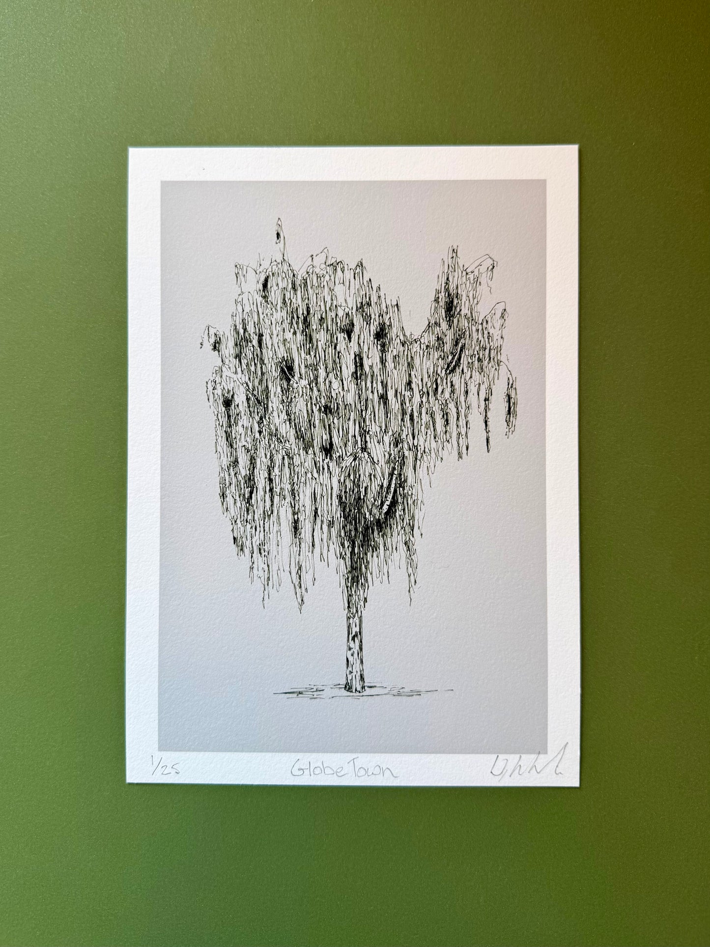 Framed black and white tree illustration on a green wall