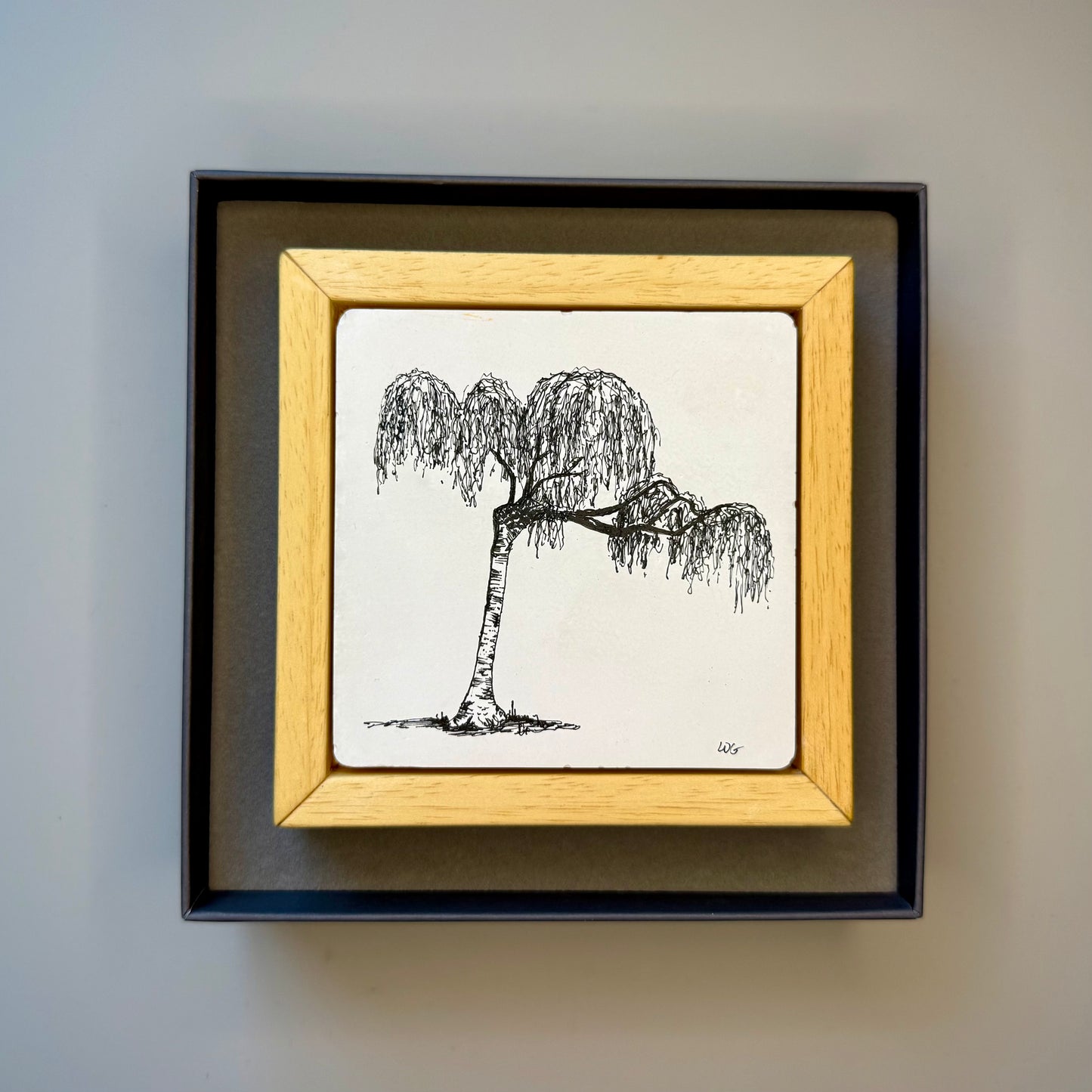 Framed black and white drawing of a tree on a plain background