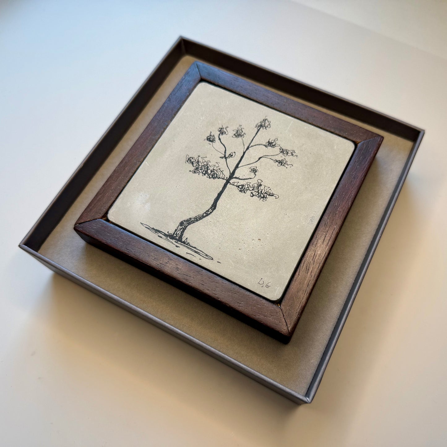 Framed artwork of a tree on a beige background