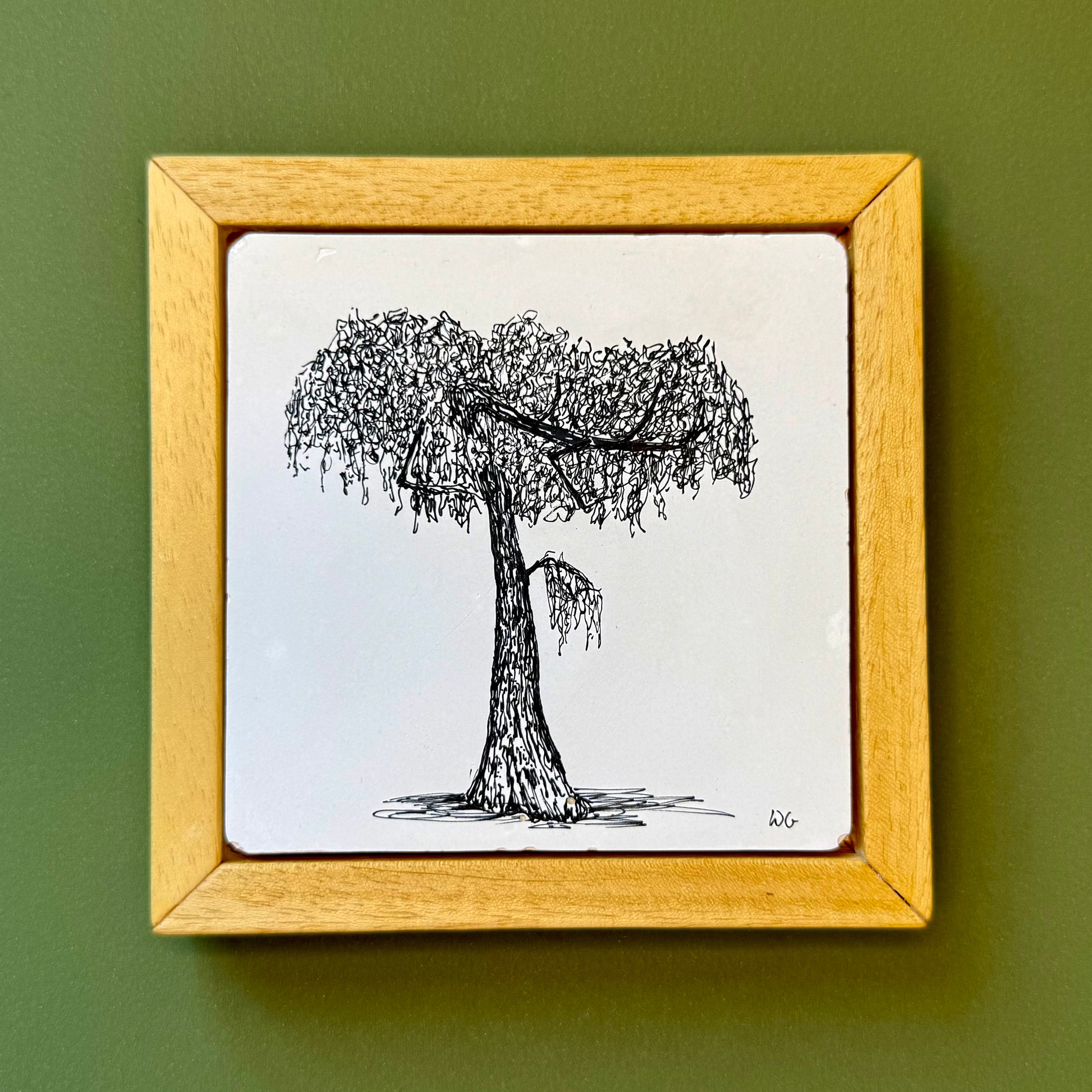 Framed drawing of a tree on a green wall