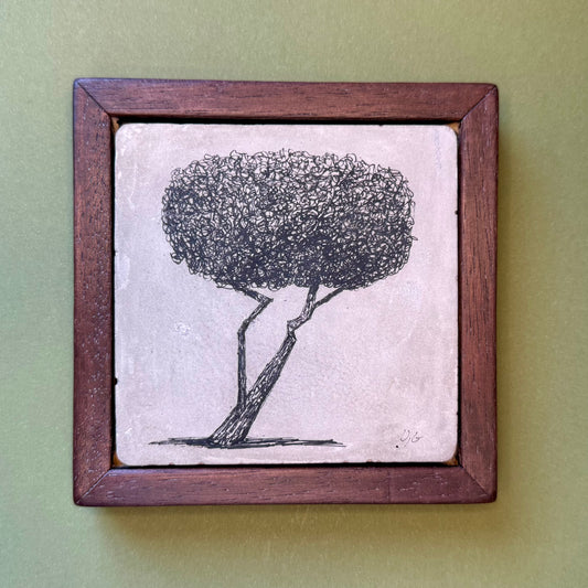 Framed artwork of a tree on a textured surface with a wooden frame.