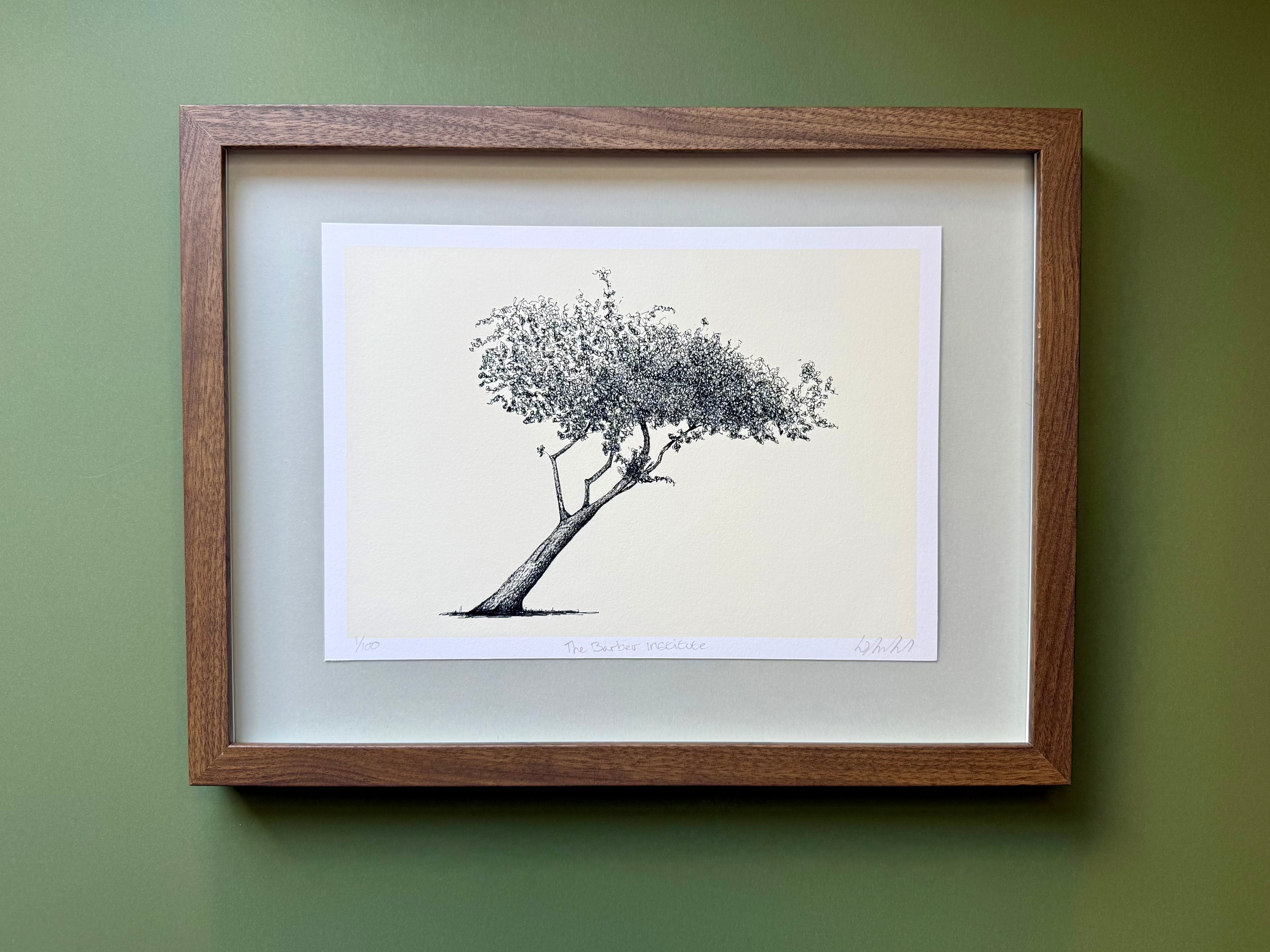 Framed artwork of a tree on a green wall