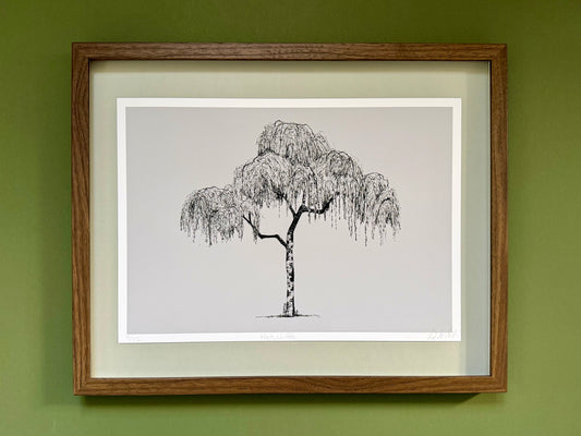 Framed black and white tree illustration on a green wall