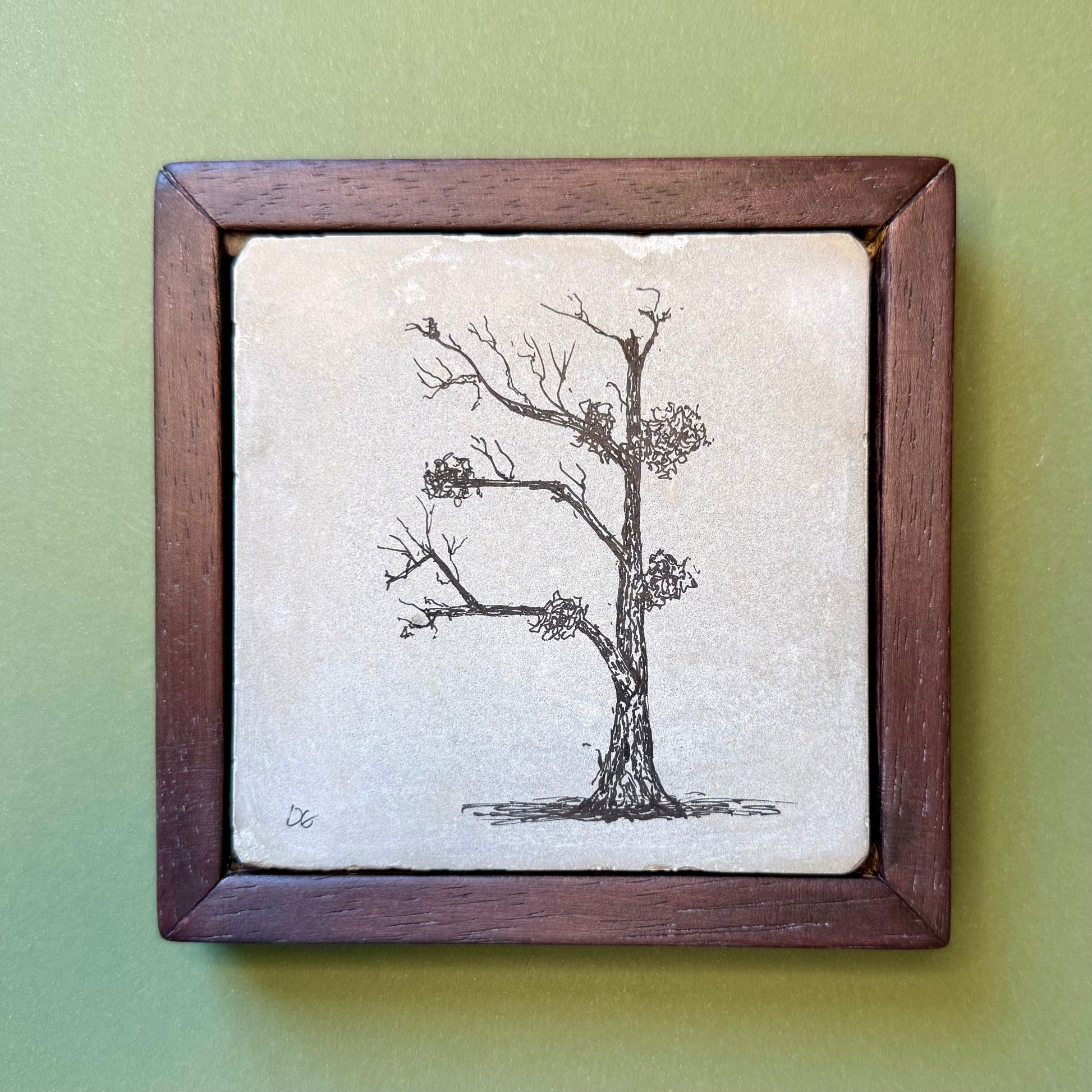 Framed artwork of a tree with nests on a light background