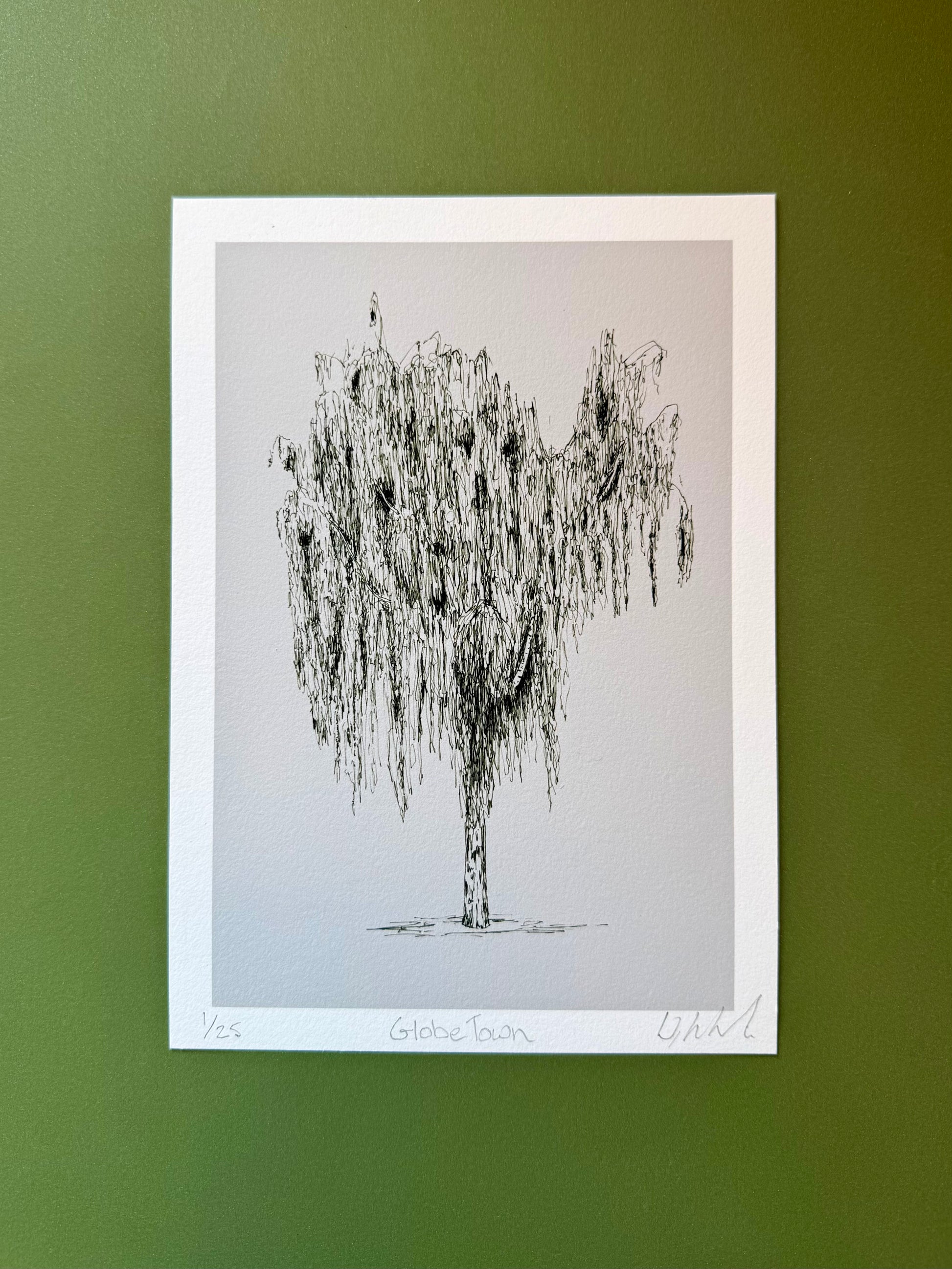 Framed black and white tree illustration on a green wall