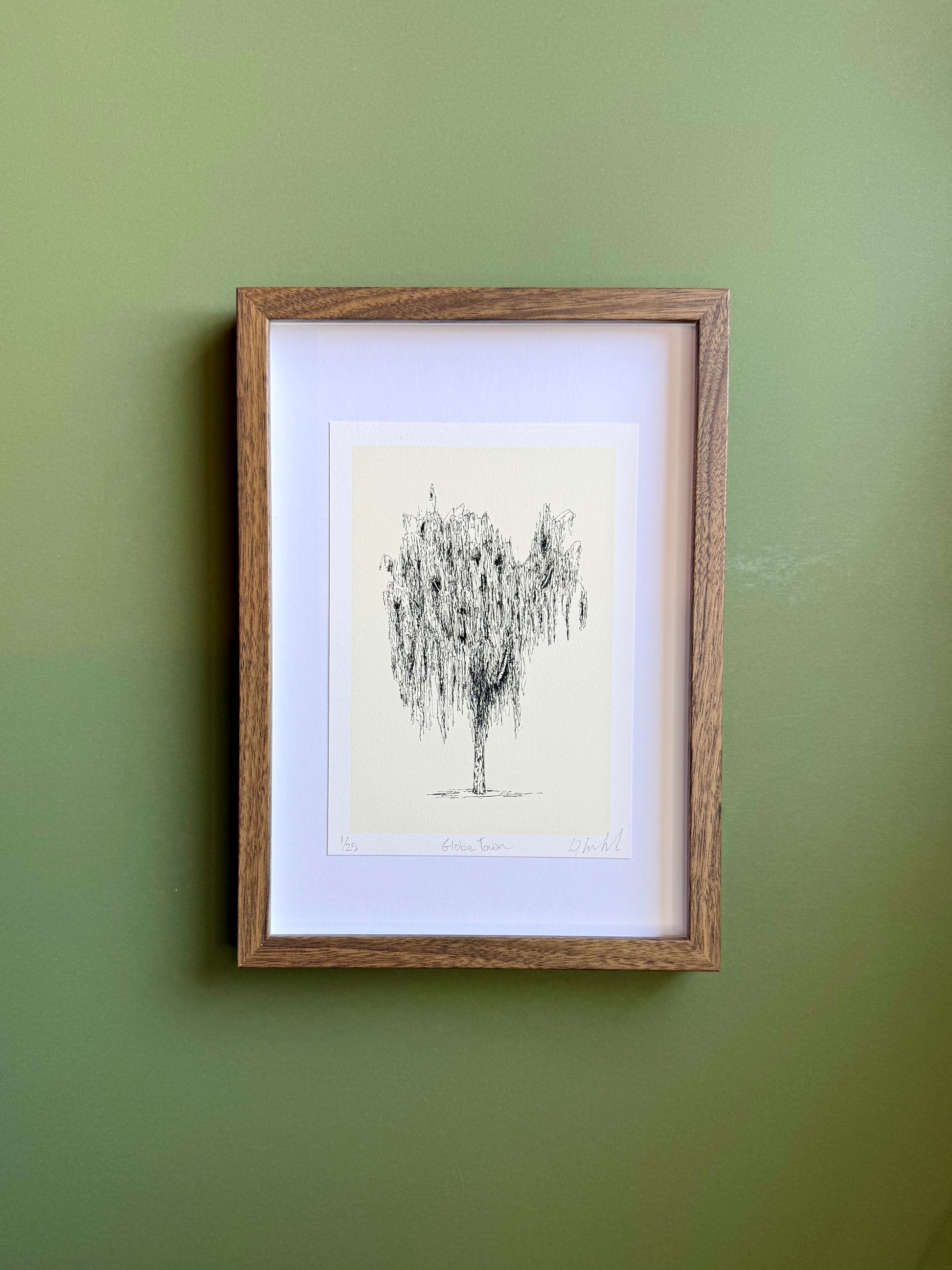 Framed artwork of a tree on a green wall