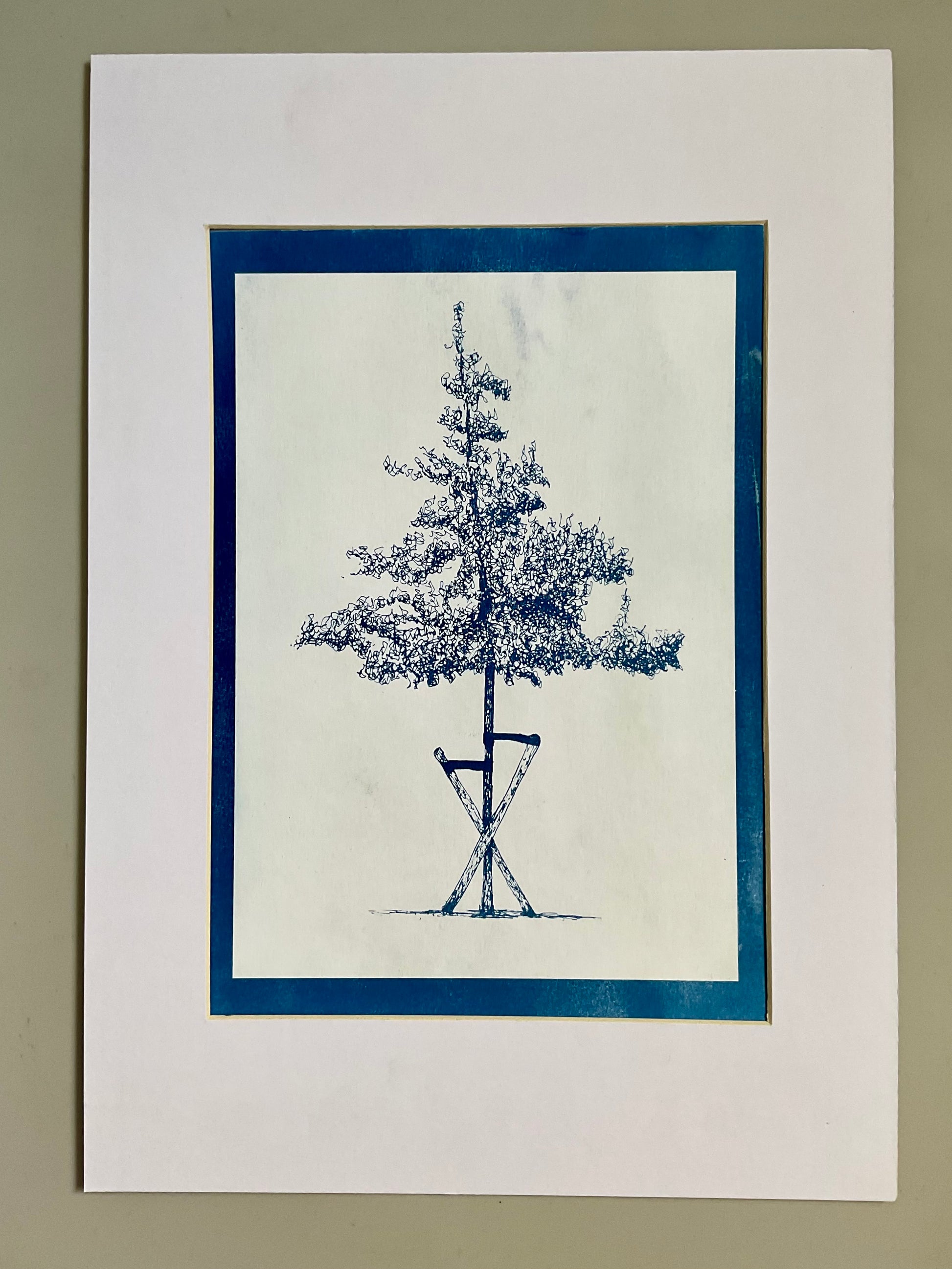 Cyanotype print of a slender tree supported by wooden stakes, printed in rich indigo tones on A4 paper.