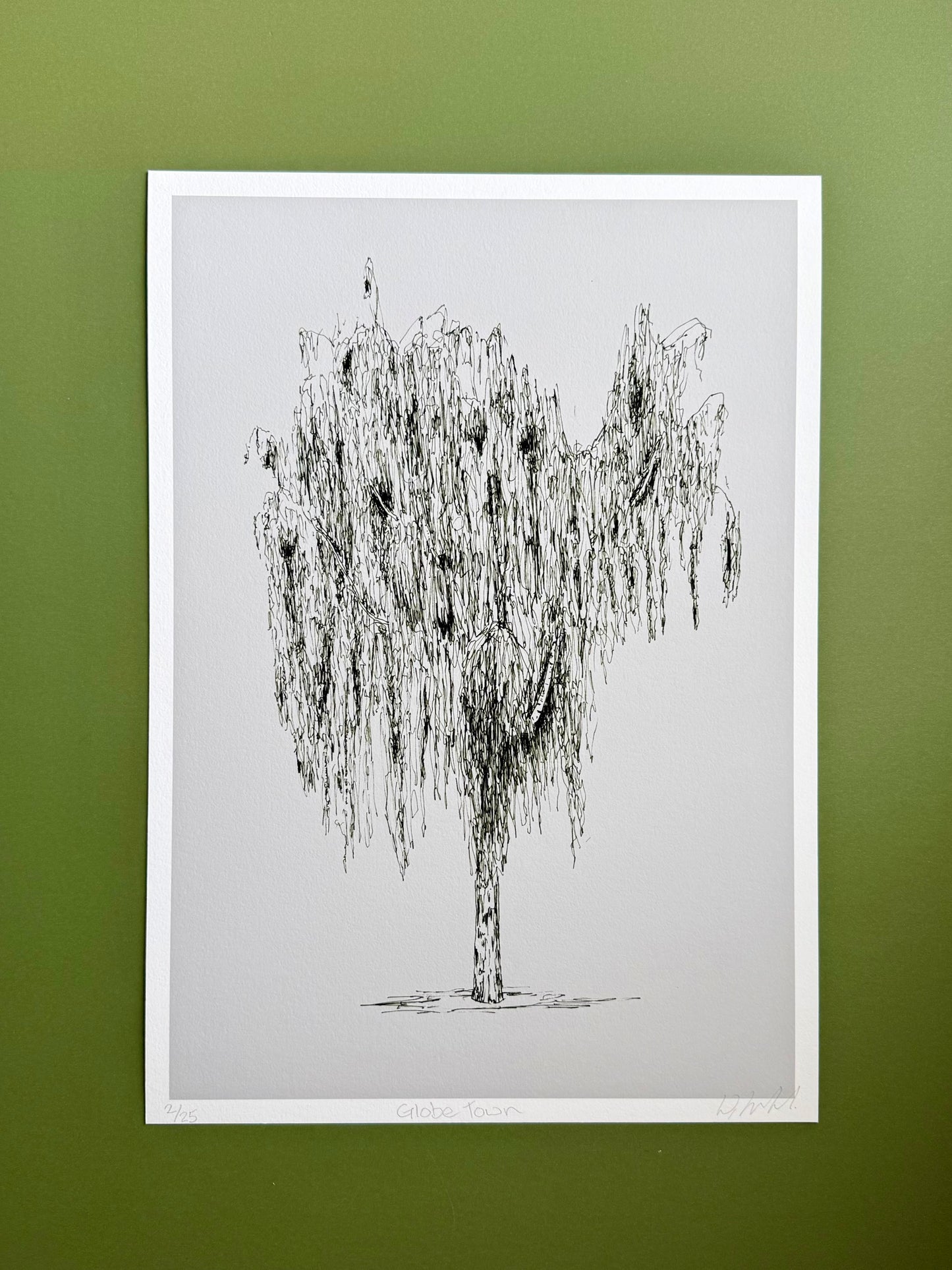 Framed black and white tree illustration on a green wall