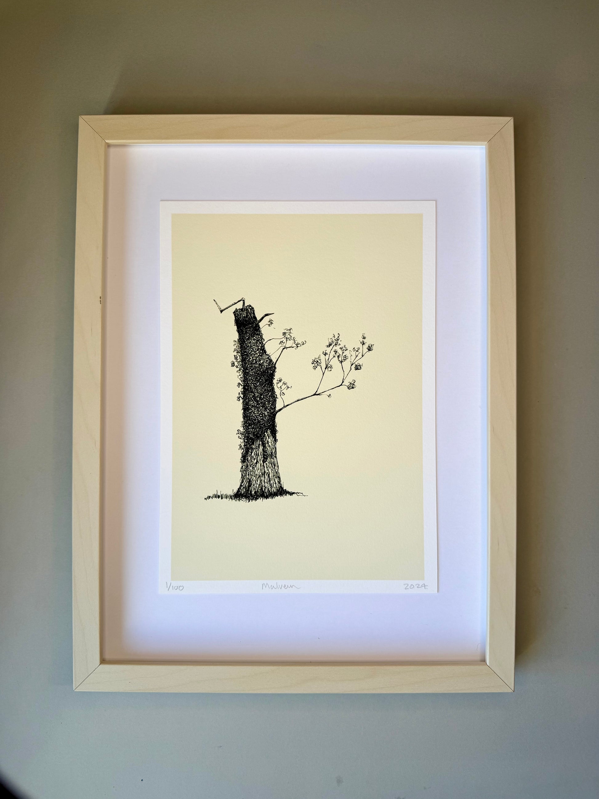 Framed artwork of a tree on a beige background