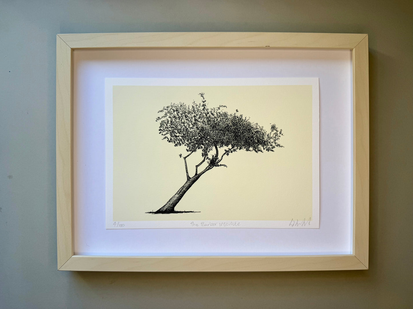 Framed black and white tree print on a beige background
