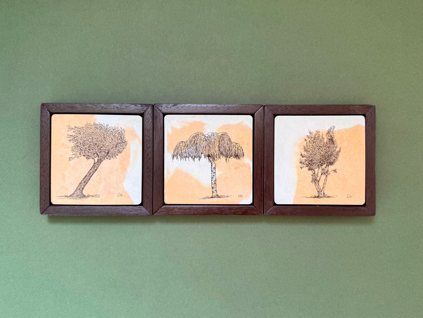 Three original ink tree drawings on hand-cast cement tiles in dark wooden frames, featuring a leaning tree, silver birch and multi-stem tree by Birmingham artist Warren Garland.
