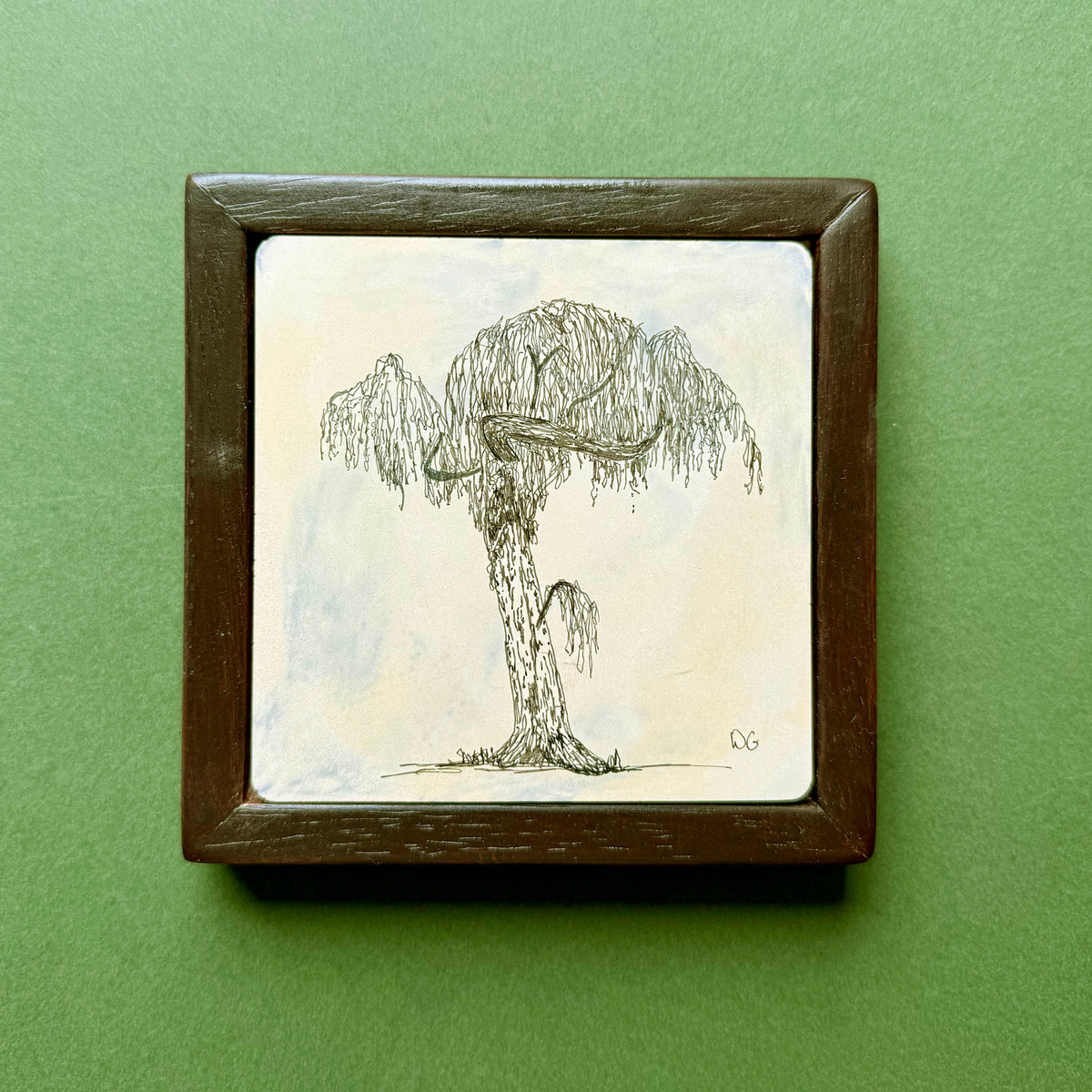 Original black ink drawing of a tree in Victoria Park, London, with a thick trunk and drooping willow-like branches. Drawn on hand-cast pigmented Portland cement with subtle blue and cream tones, presented in a dark wooden frame against a green background.
